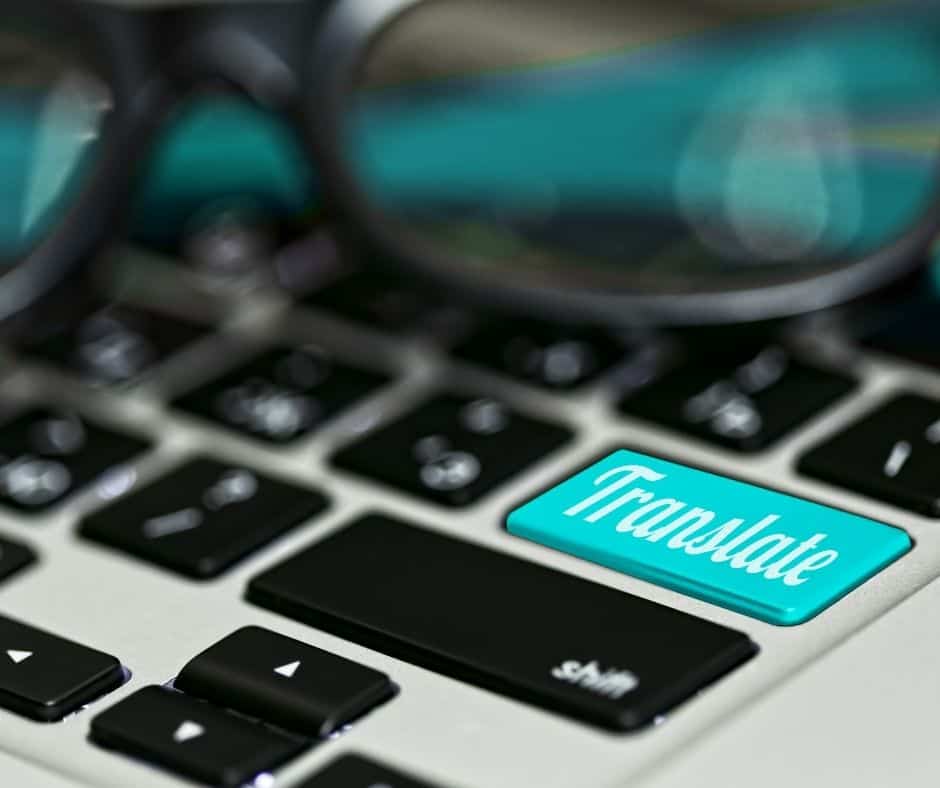 Computer keyboard with glasses and a turquoise key saying translate