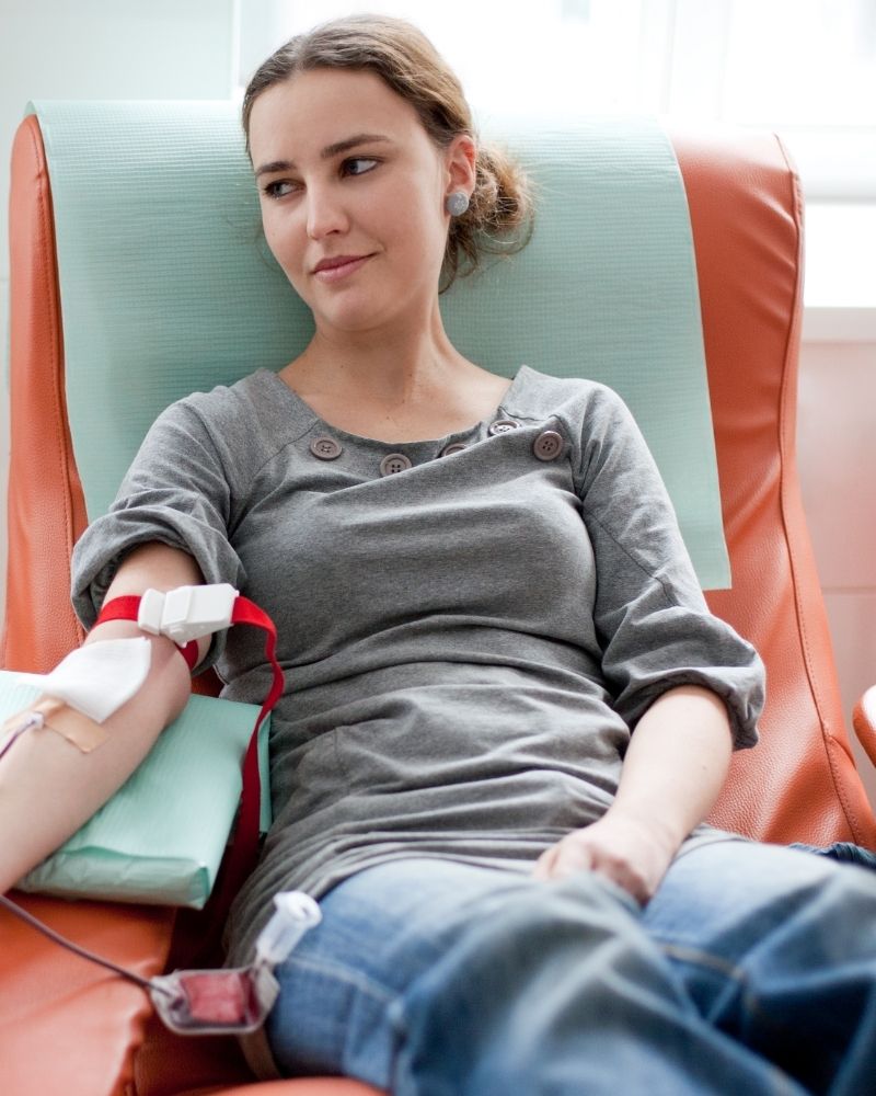 Young women sitting in a chair getting a blood transfusion